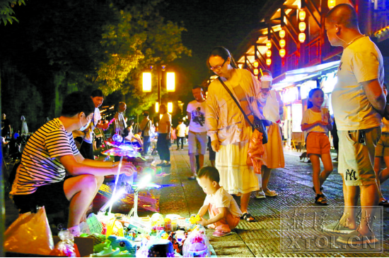 夜晚的窑湾灯火通明非常热闹，许多市民在这里散步、购物。（记者 罗韬 摄）